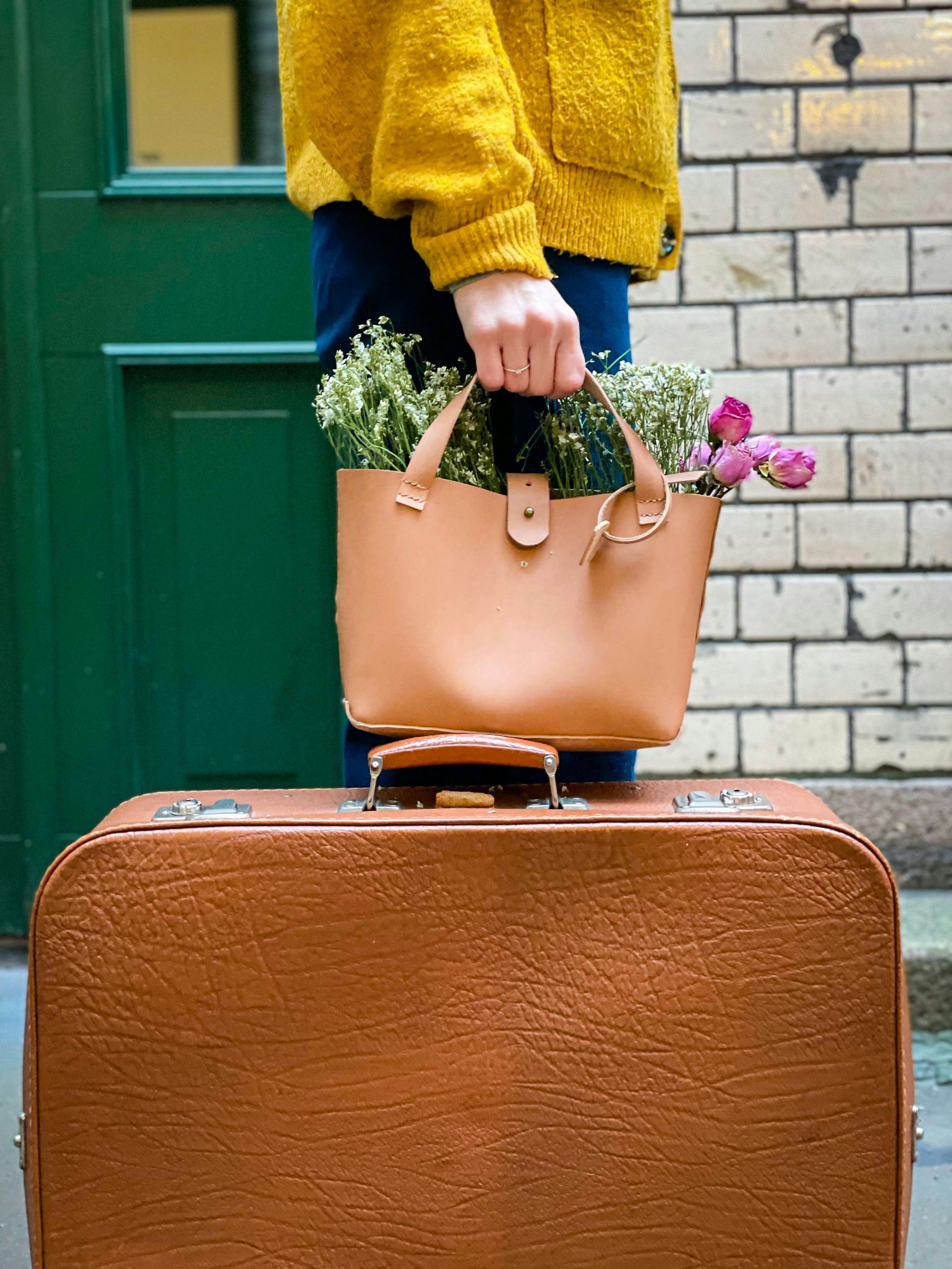 Blumen in einer Tasche als Symbol eines freundlichen und frischen Tourismus.