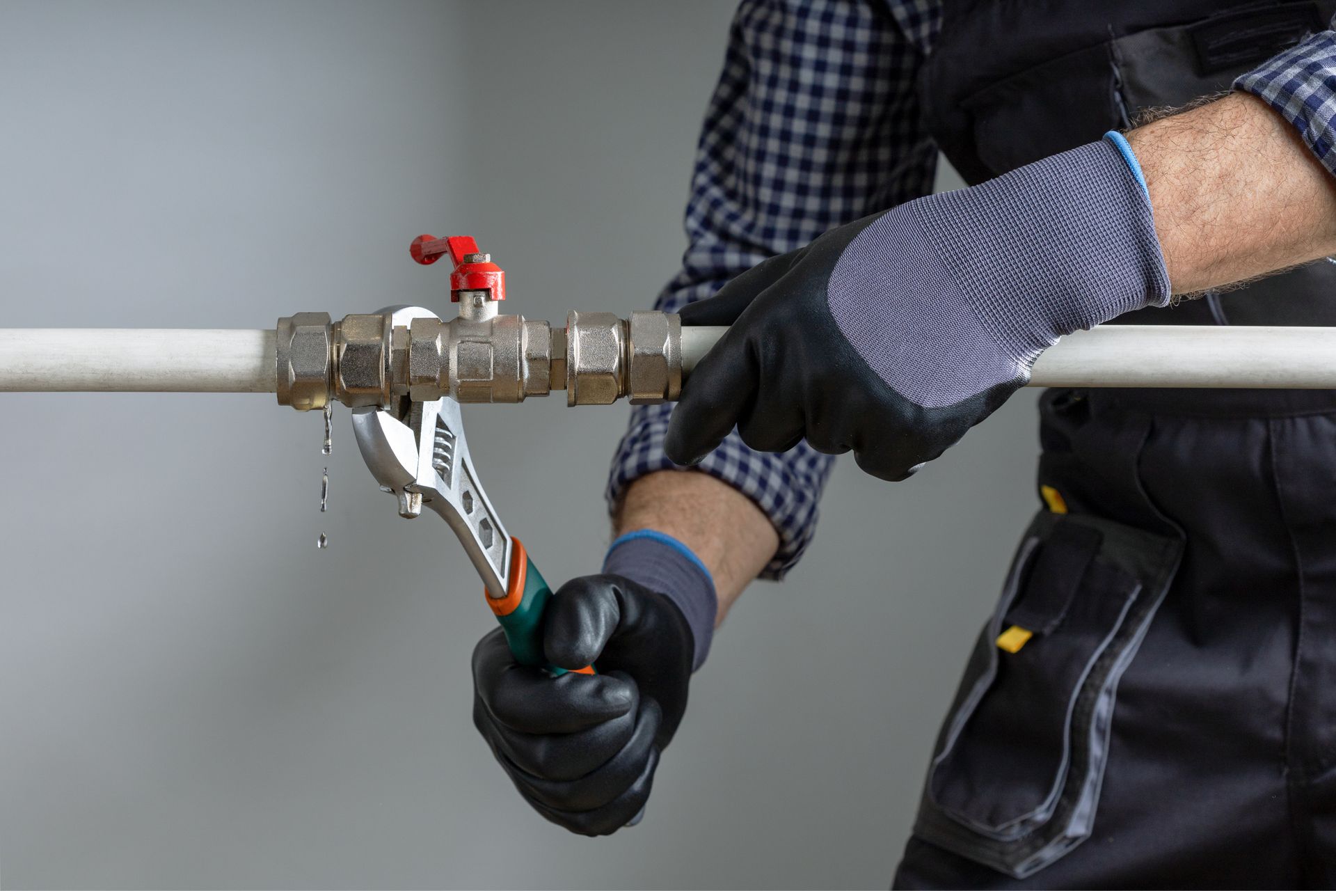 Professional plumber fixing a leaking pipe joint with an adjustable wrench. Professional plumber fixing a leaking pipe joint with an adjustable wrench.