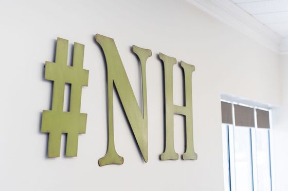 The letters nh are hanging on a white wall