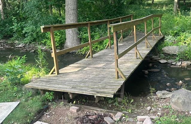 A wooden bridge over a stream in the woods