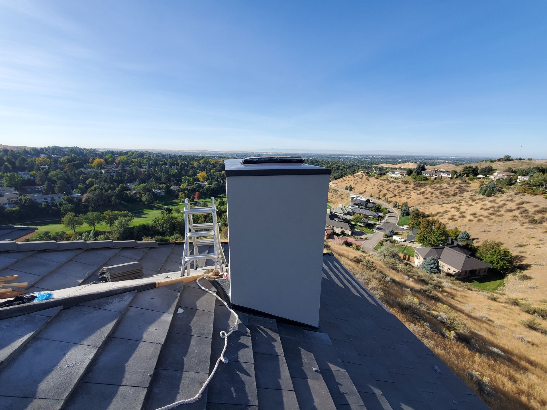 Insulated HVAC ductwork in an attic, running through insulation and between wooden beams.