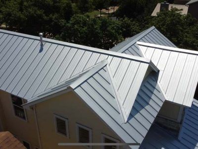 An aerial view of a house with a metal roof