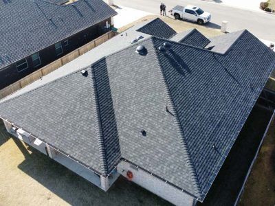 An aerial view of a house with a black roof.