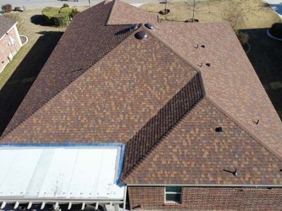 An aerial view of a brick house with a brown roof.
