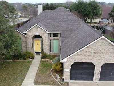 An aerial view of a brick house with a new roof.