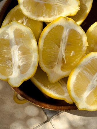 Sliced yellow lemons in a brown bowl, bright and juicy.