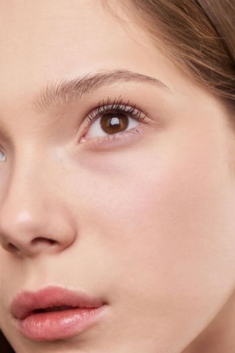 Close-up of a person with light skin and brown eyes. They have natural makeup and a neutral expression.