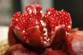 Open pomegranate, revealing many red seeds.
