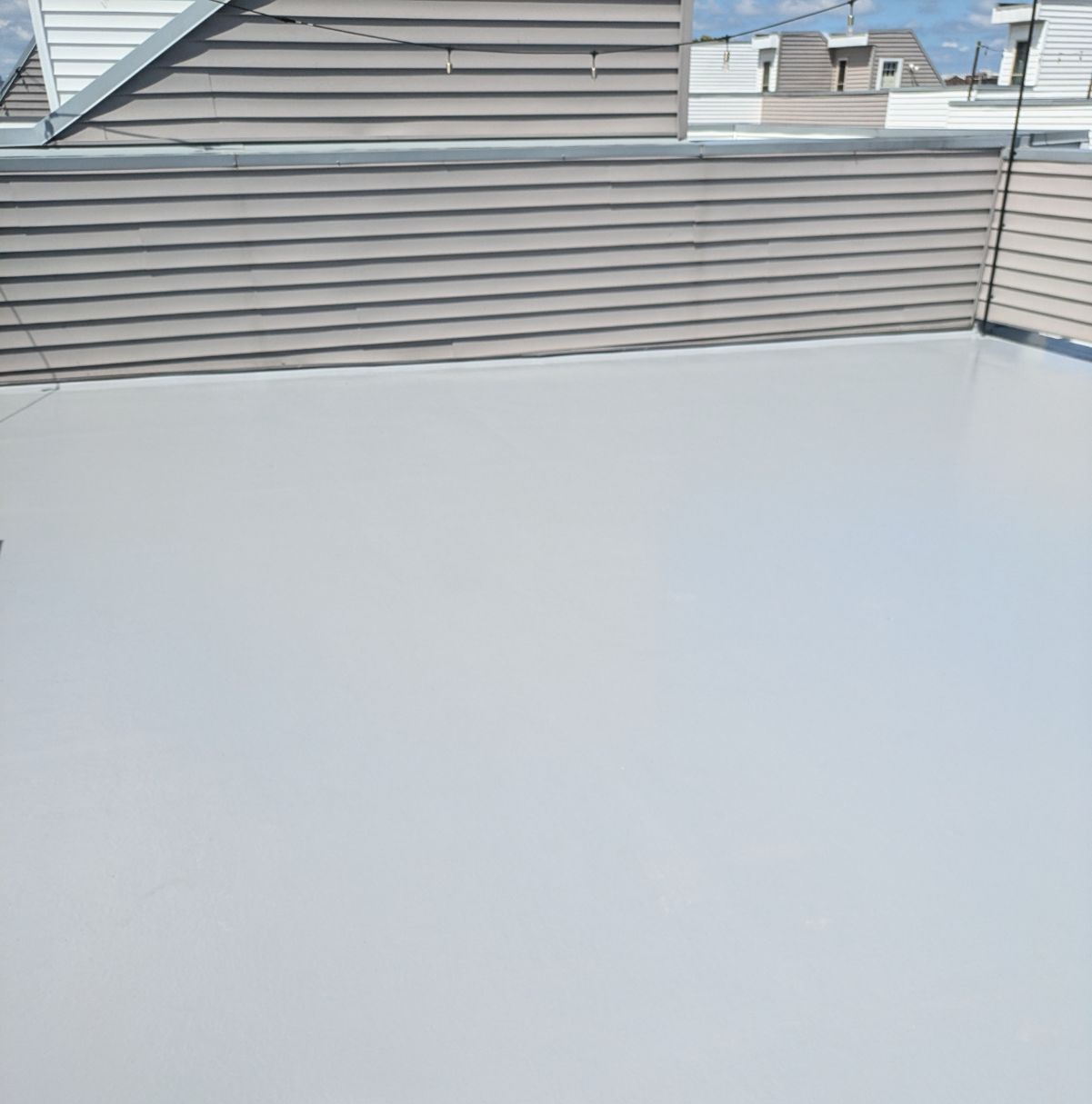 A white roof with a wooden fence in the background.