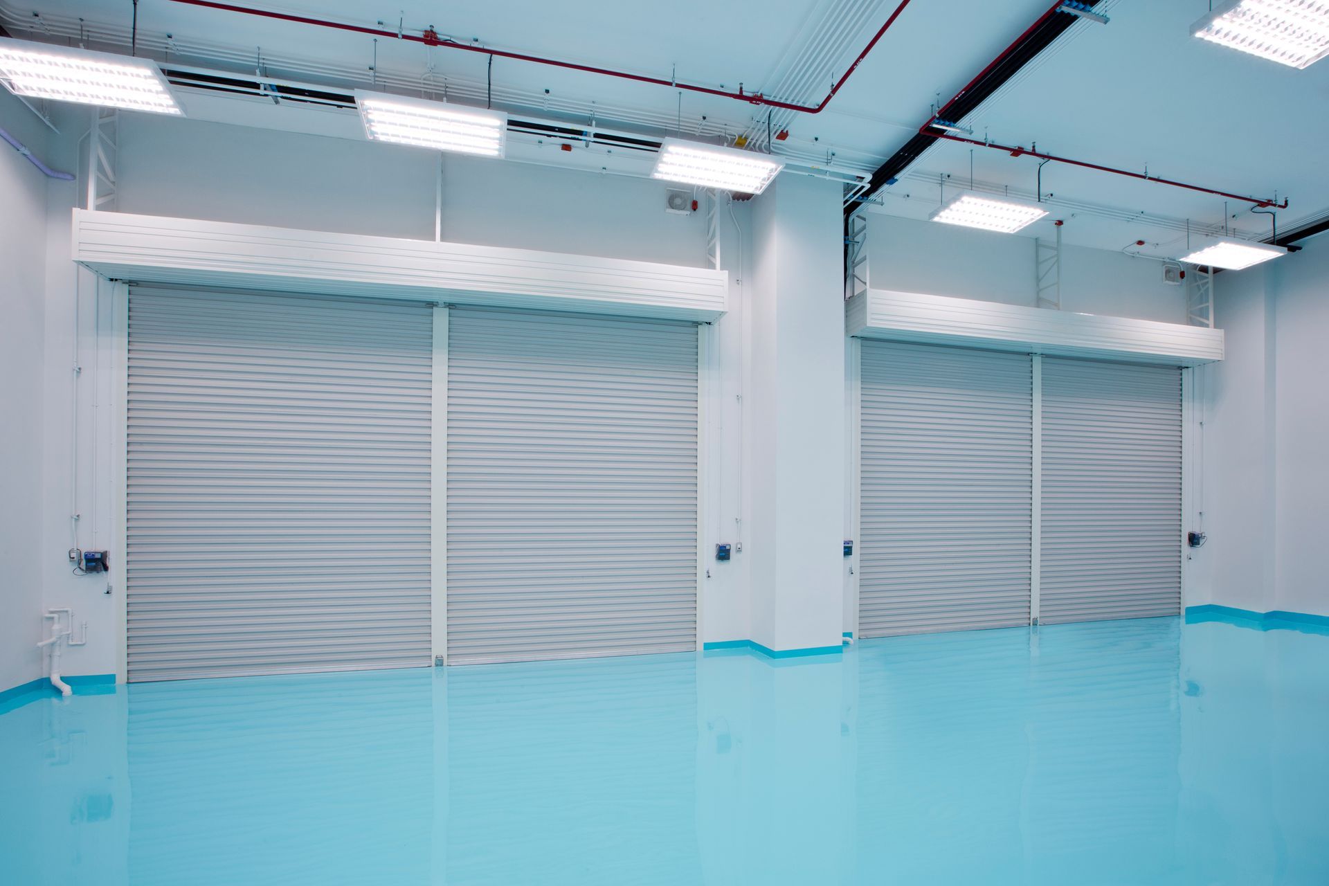 A large empty room with blue floors and white walls.