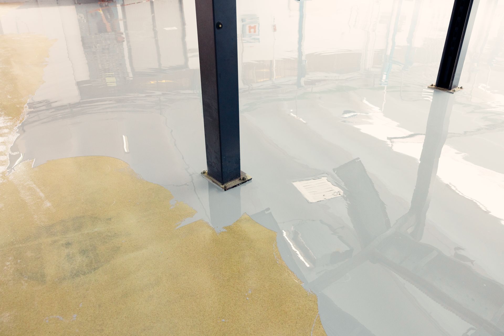 A close up of a concrete floor with a pillar in the background.