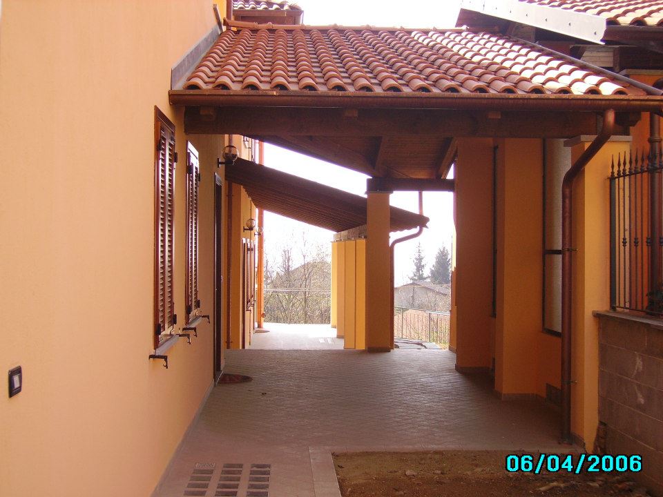 Passaggio coperto con pareti arancioni, tegole in terracotta e travi in ​​legno marrone.