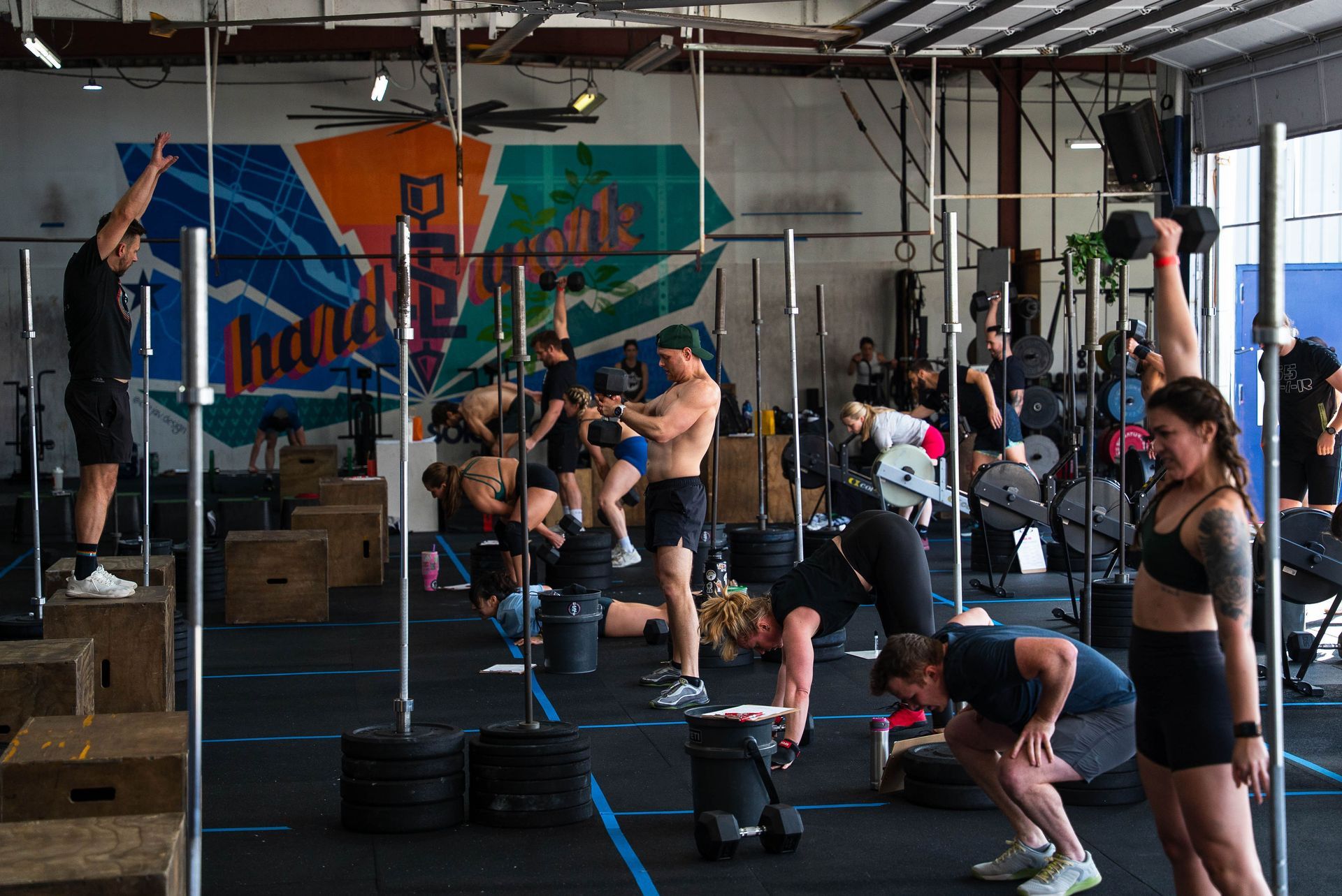 Two shirtless men are riding exercise bikes in a gym.