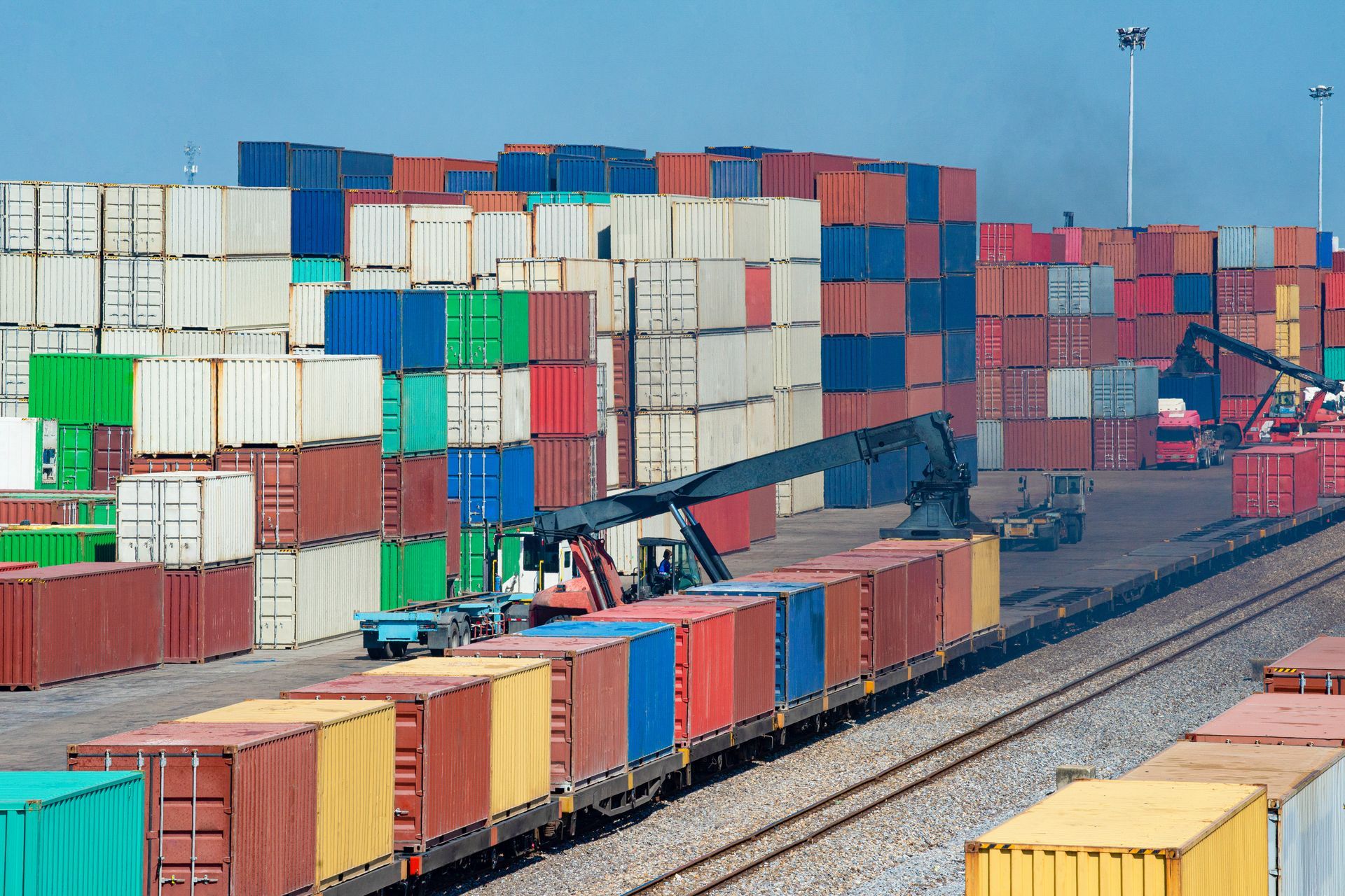 a train is being loaded with containers at a port .