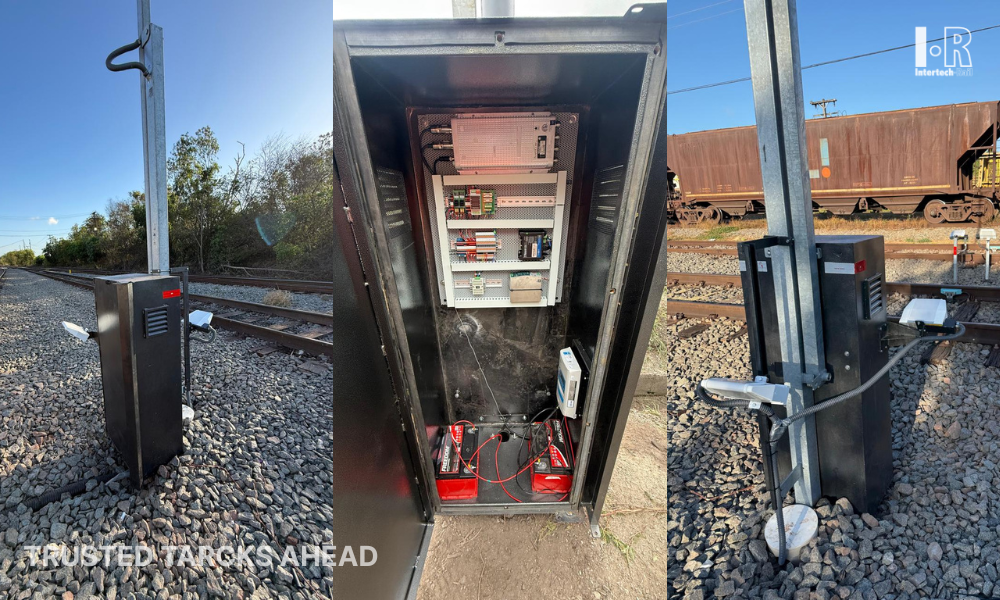 Open utility box with electrical equipment inside beside the railroad tracks