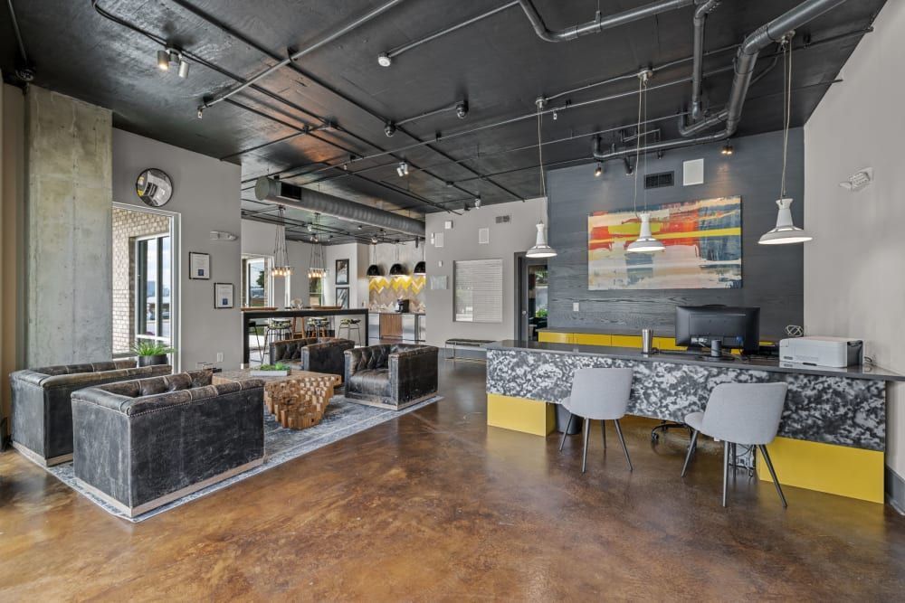 Spacious clubhouse with a lot of furniture and a desk with computer and printer at Skyline West in Atlanta, GA.