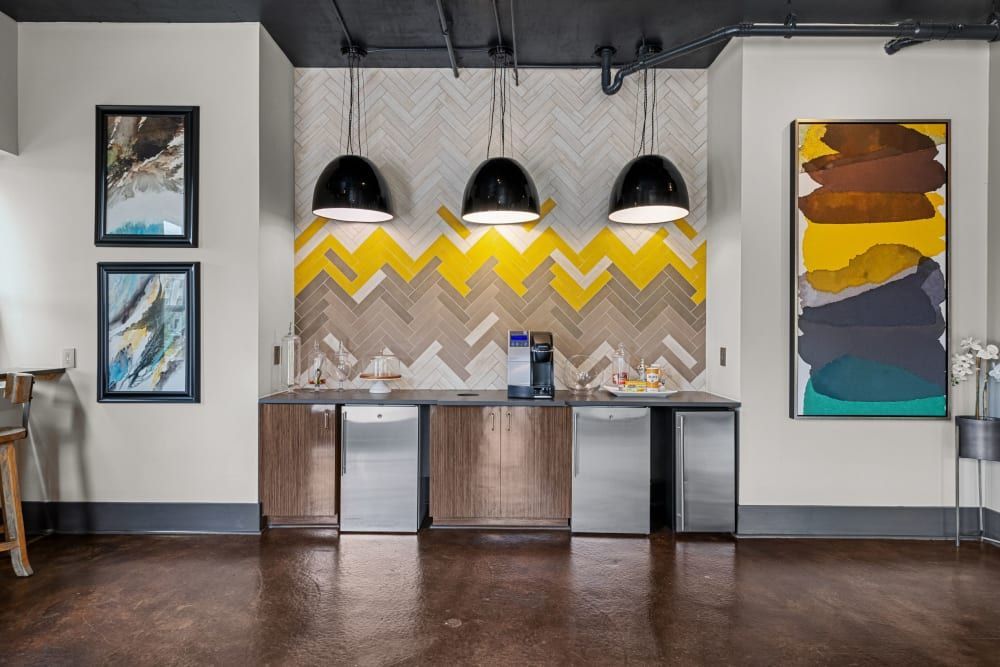 Apartment community kitchen with countertop space, coffee machine, and a chevron wall at Skyline West in Atlanta, GA.