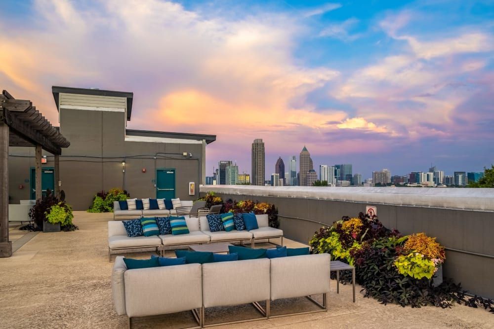 A rooftop terrace with a view of the city skyline at sunset at Skyline West in Atlanta, GA.