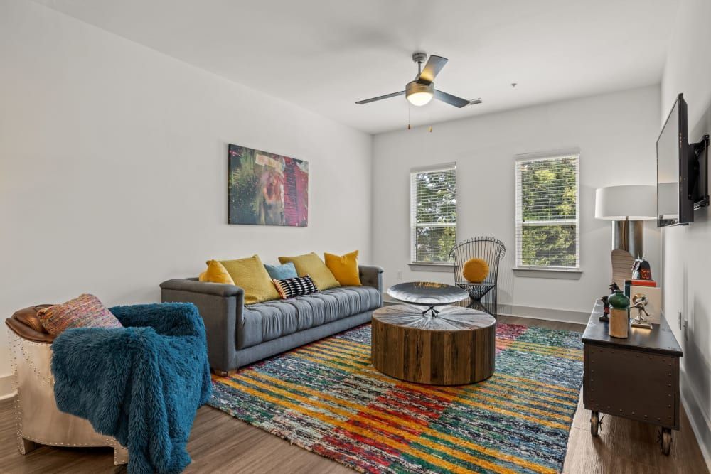 Apartment living room with a couch, chair, coffee table, and television at Skyline West in Atlanta, GA.