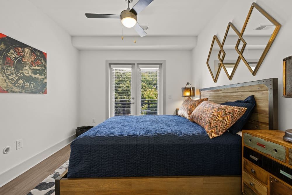 Apartment bedroom with a large bed and a ceiling fan at Skyline West in Atlanta, GA.