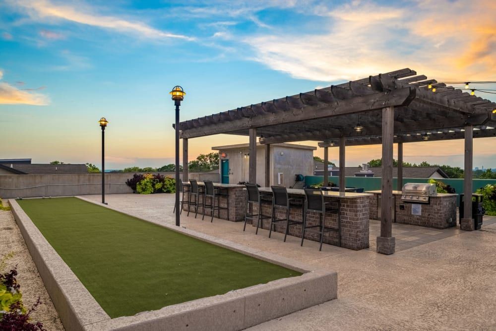 A rooftop patio with a bocce ball court and a grill at Skyline West in Atlanta, GA.