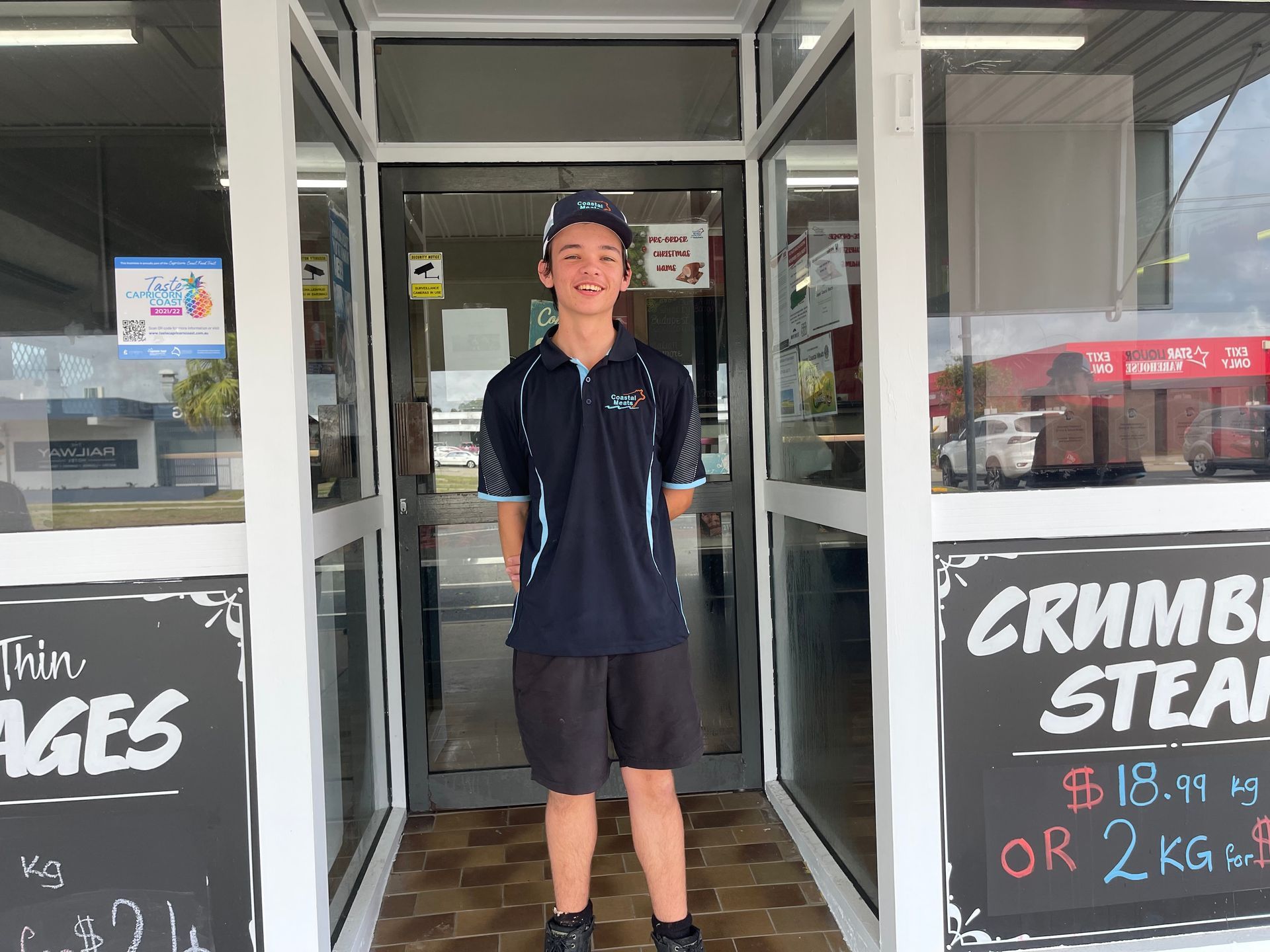 Young Person Wearing a Uniform Stands in the Doorway of a Shop — Coastal Meats in Yeppoon, QLD