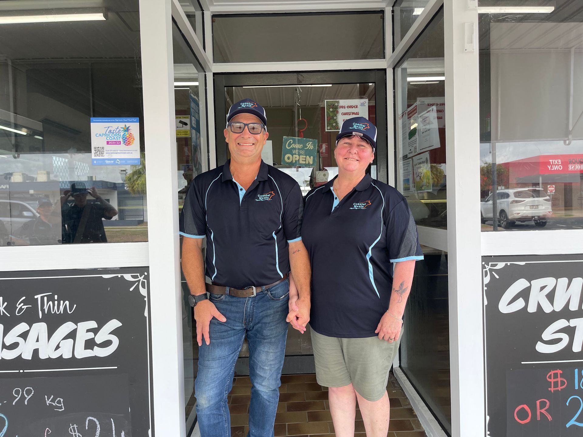 Two People Stand in a Butcher Shop Doorway, Smiling — Coastal Meats in Yeppoon, QLD