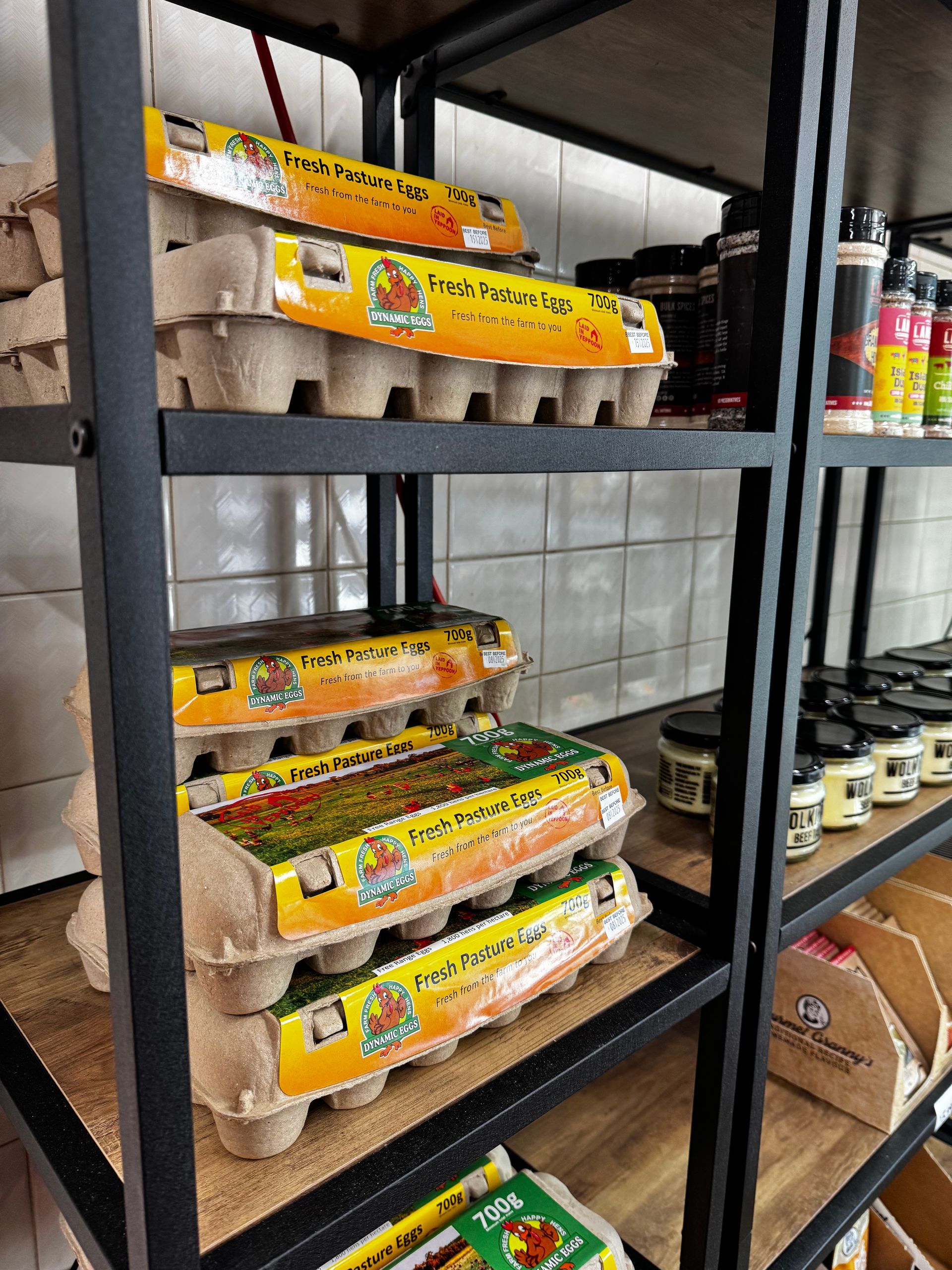 Shelves with cartons of eggs stacked in a shop. Various other food items and condiments on the shelves — Coastal Meats in Yeppoon, QLD