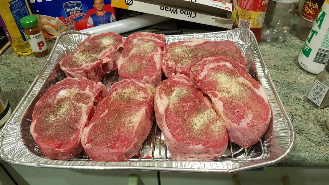 A Tray of Meat Sits on a Counter Next to a Box Of Cling Wrap — Coastal Meats in Yeppoon, QLD