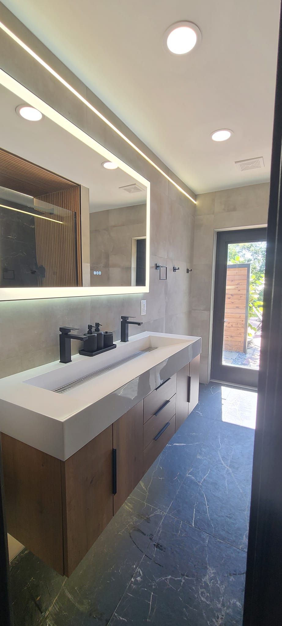 A bathroom with two sinks , a mirror and a door.