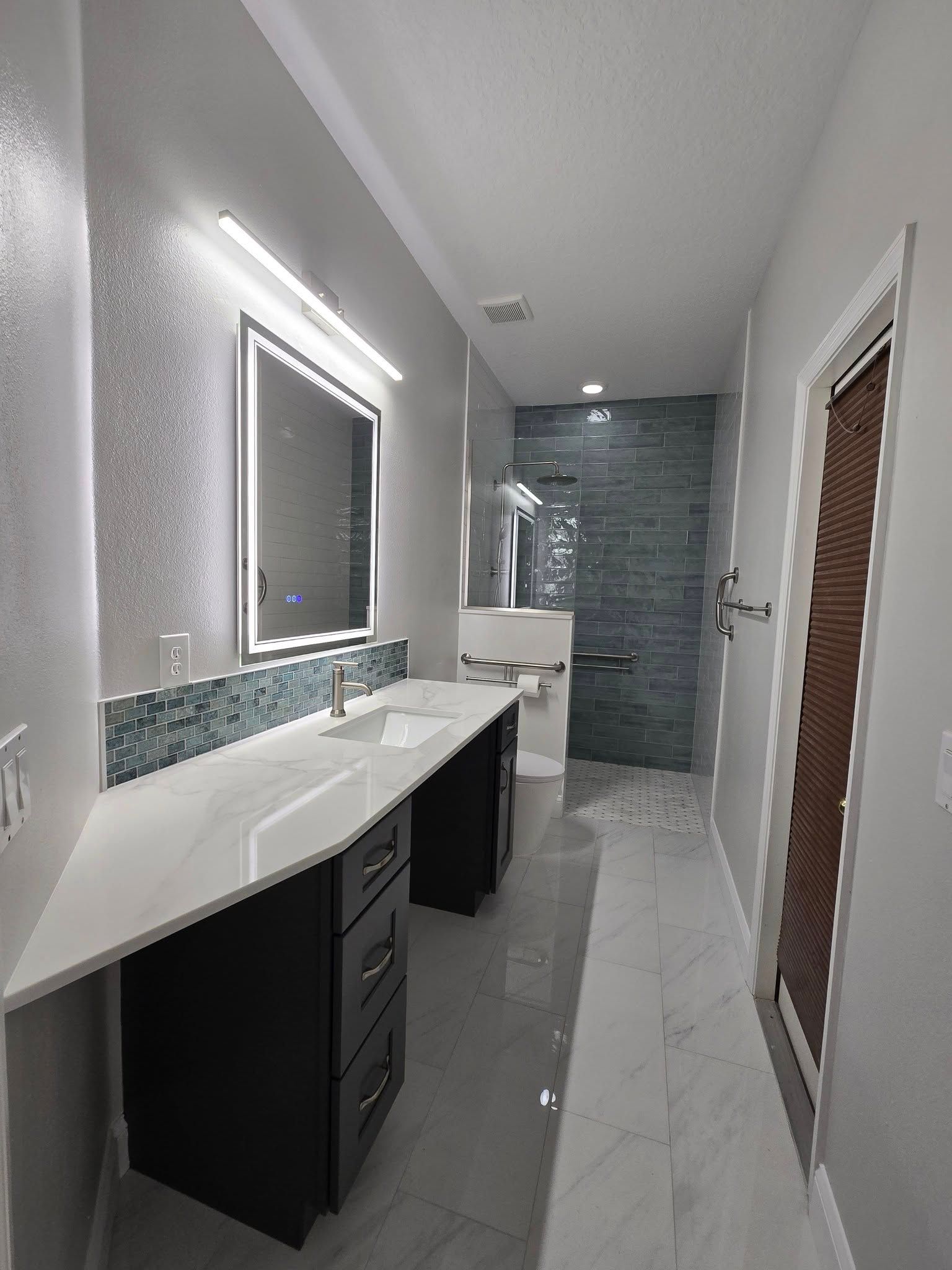 A bathroom with a sink , mirror and trash can.