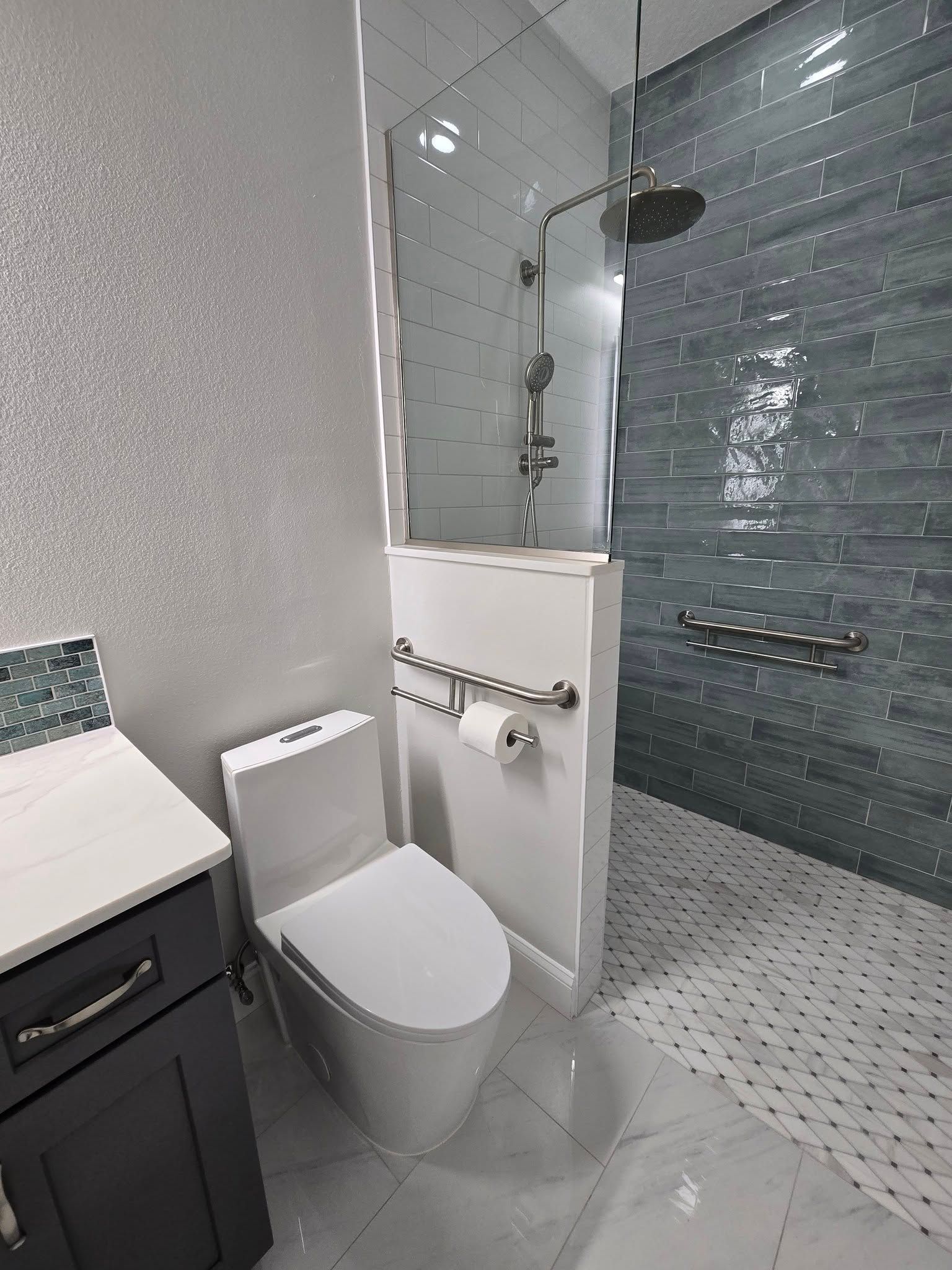 A bathroom with a toilet , sink and walk in shower.