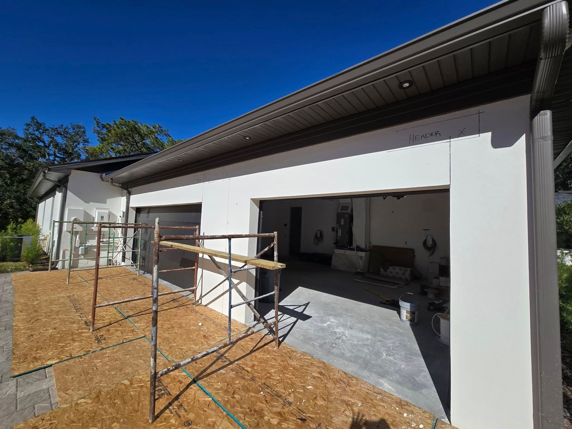 A garage is being built in the backyard of a house.