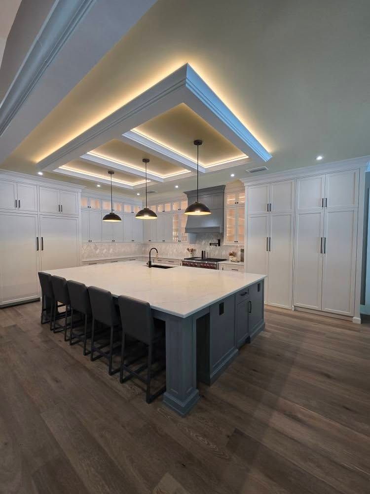 The final finished kitchen with a large island and custom lighting.