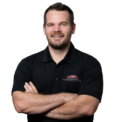 A man wearing a black polo shirt is smiling for the camera