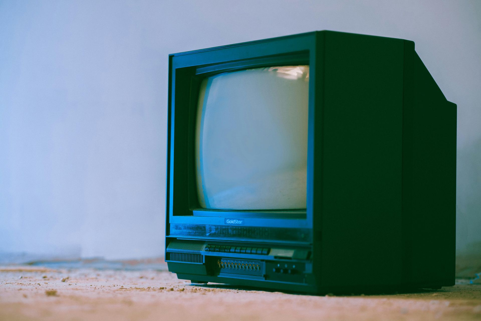 An old television is sitting on a wooden table.