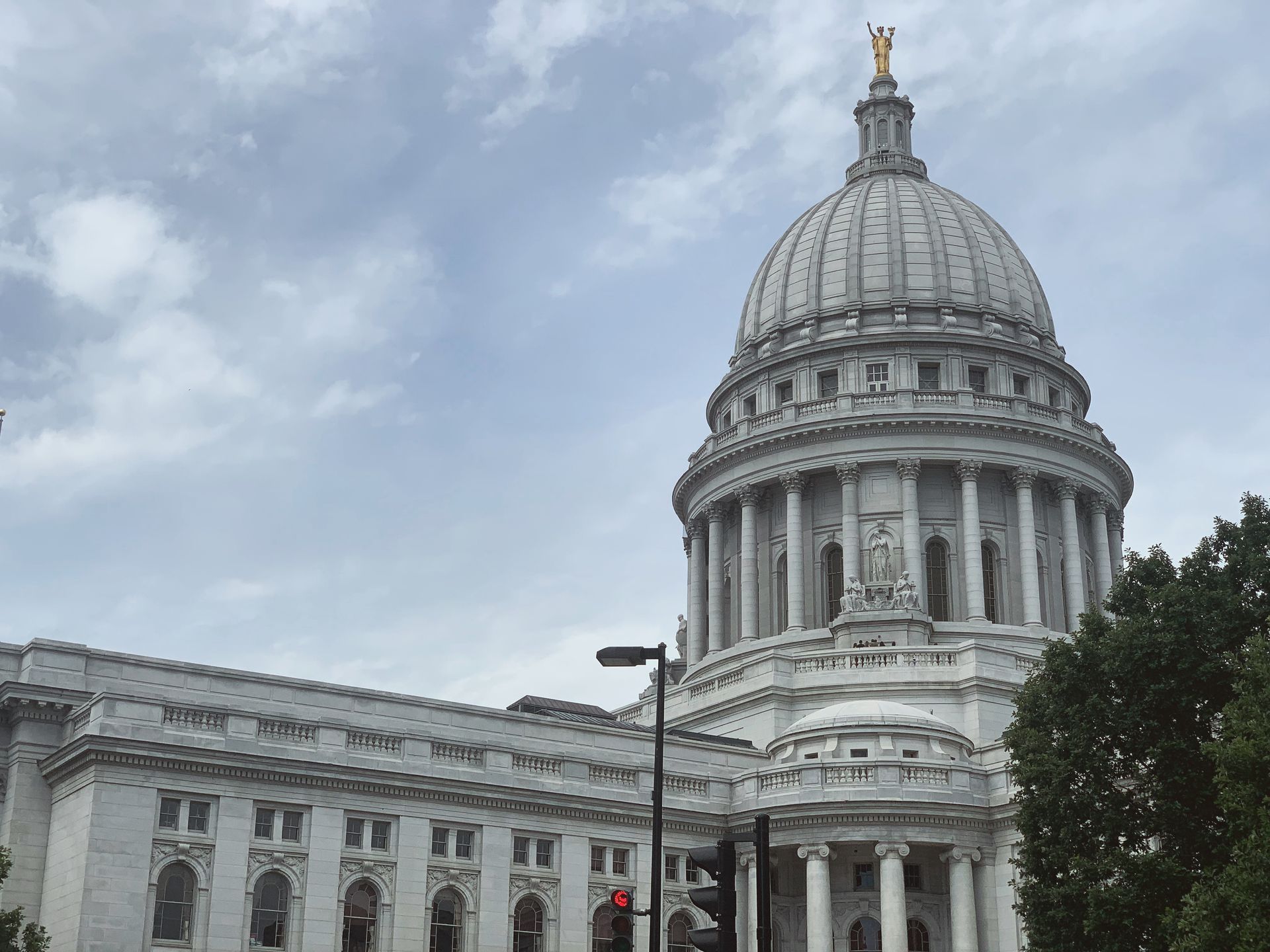 Man in suit, sitting at desk, reviewing papers, with pen in hand.