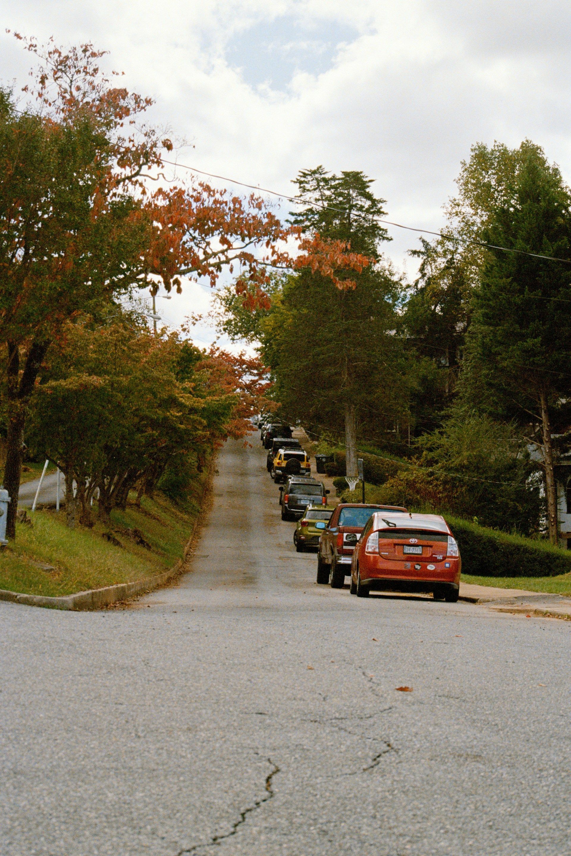 Aerial view of a large church with a teal dome, overlooking a city street with buildings and trees.