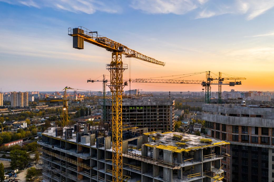 Una vista aerea di un cantiere con gru e un edificio in costruzione.