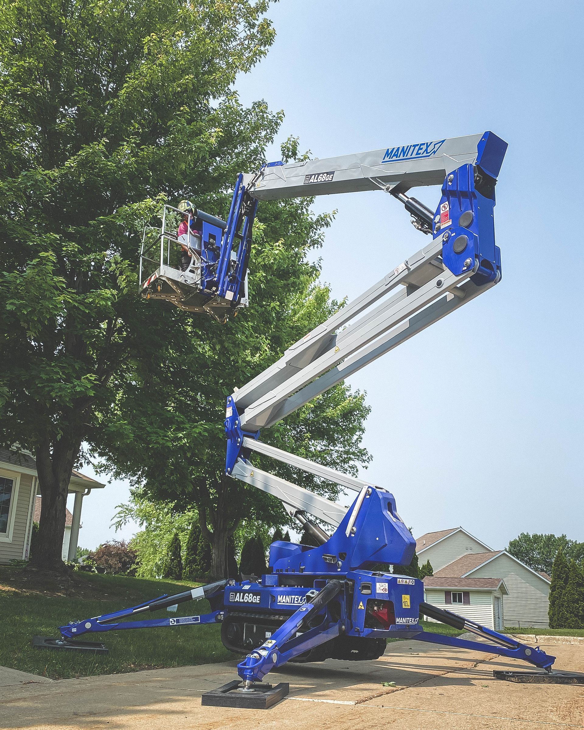 A blue and silver aerial lift with a person in it
