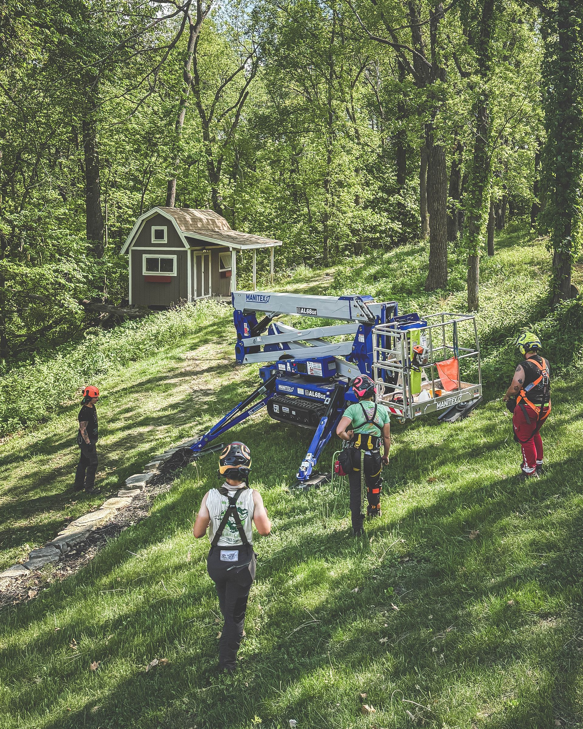 A group of people are walking in the woods near a house.