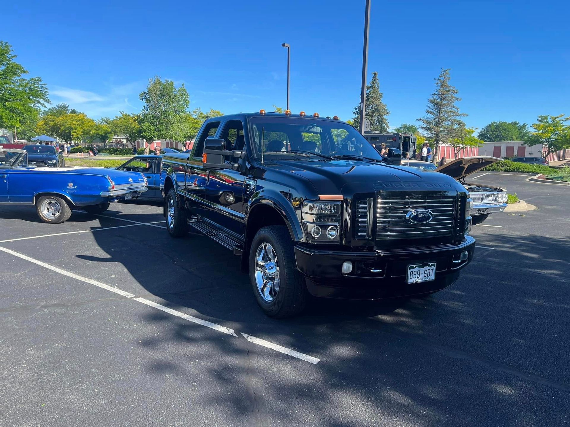 A black ford truck is parked in a parking lot