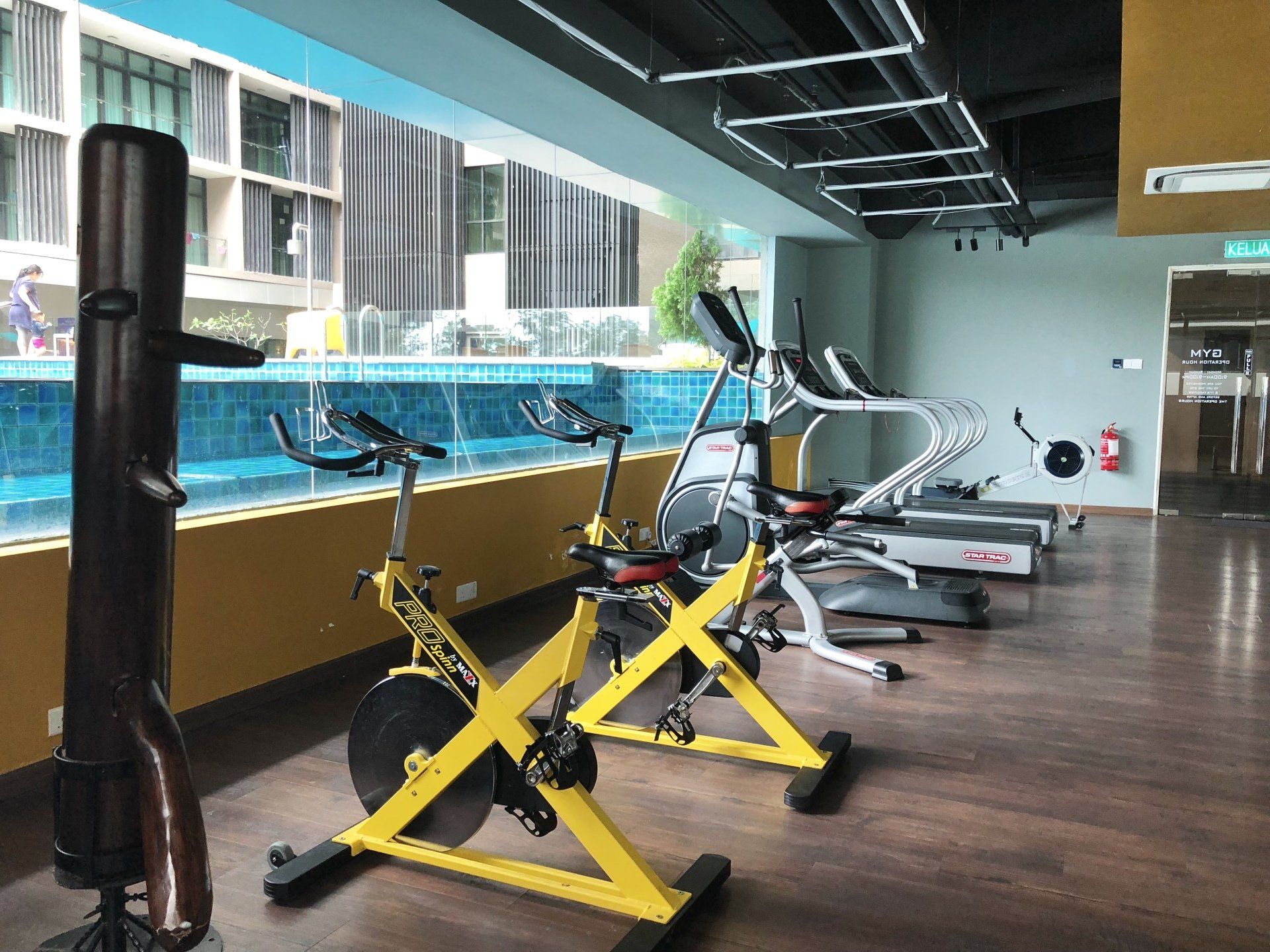 A gym with a row of exercise bikes and treadmills