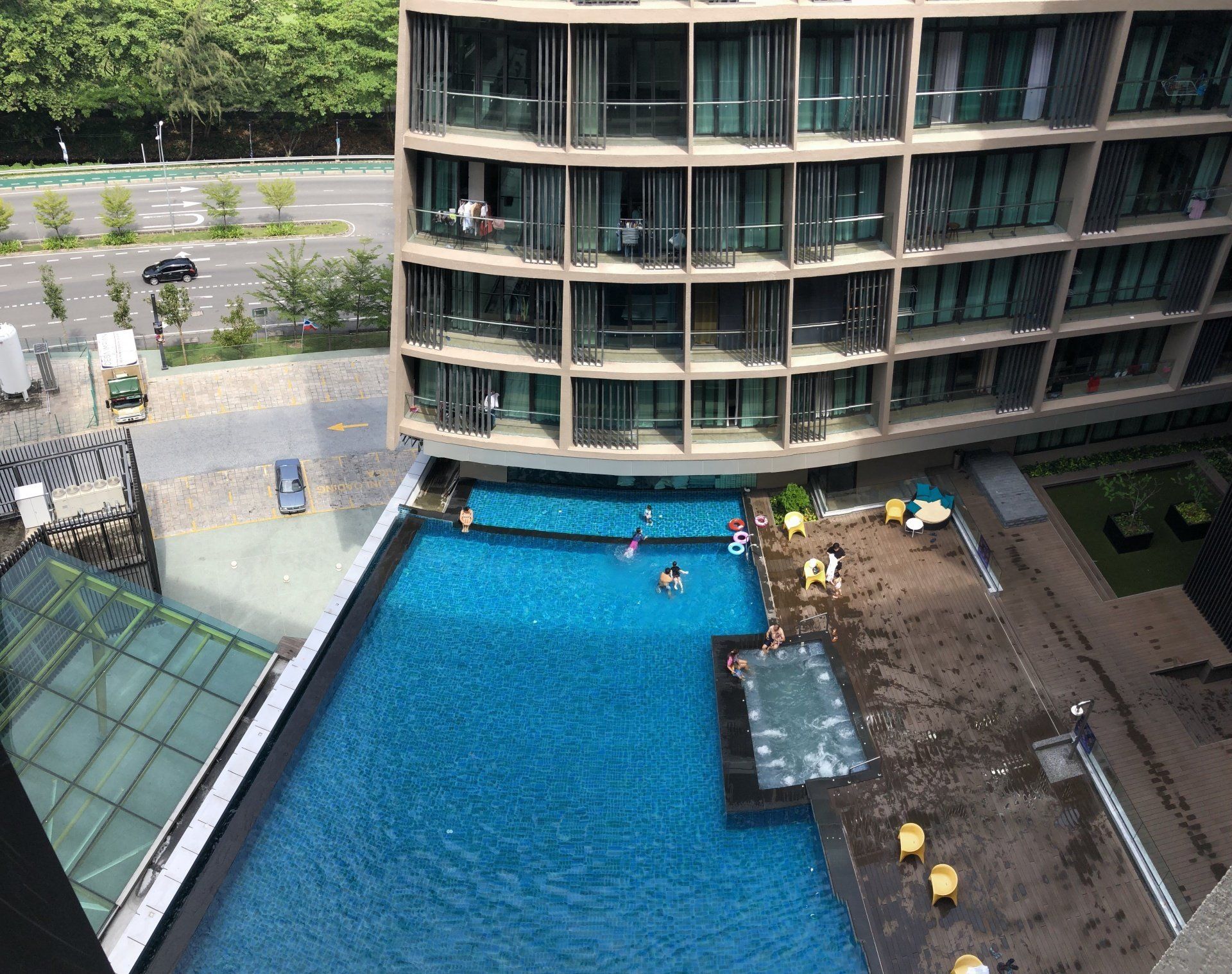 An aerial view of a large swimming pool in front of a building.