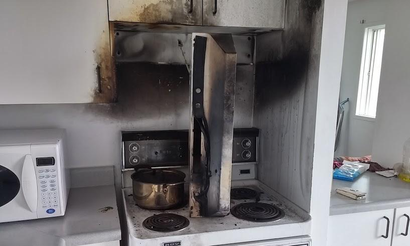 Une cuisine avec une cuisinière, un four et un micro-ondes