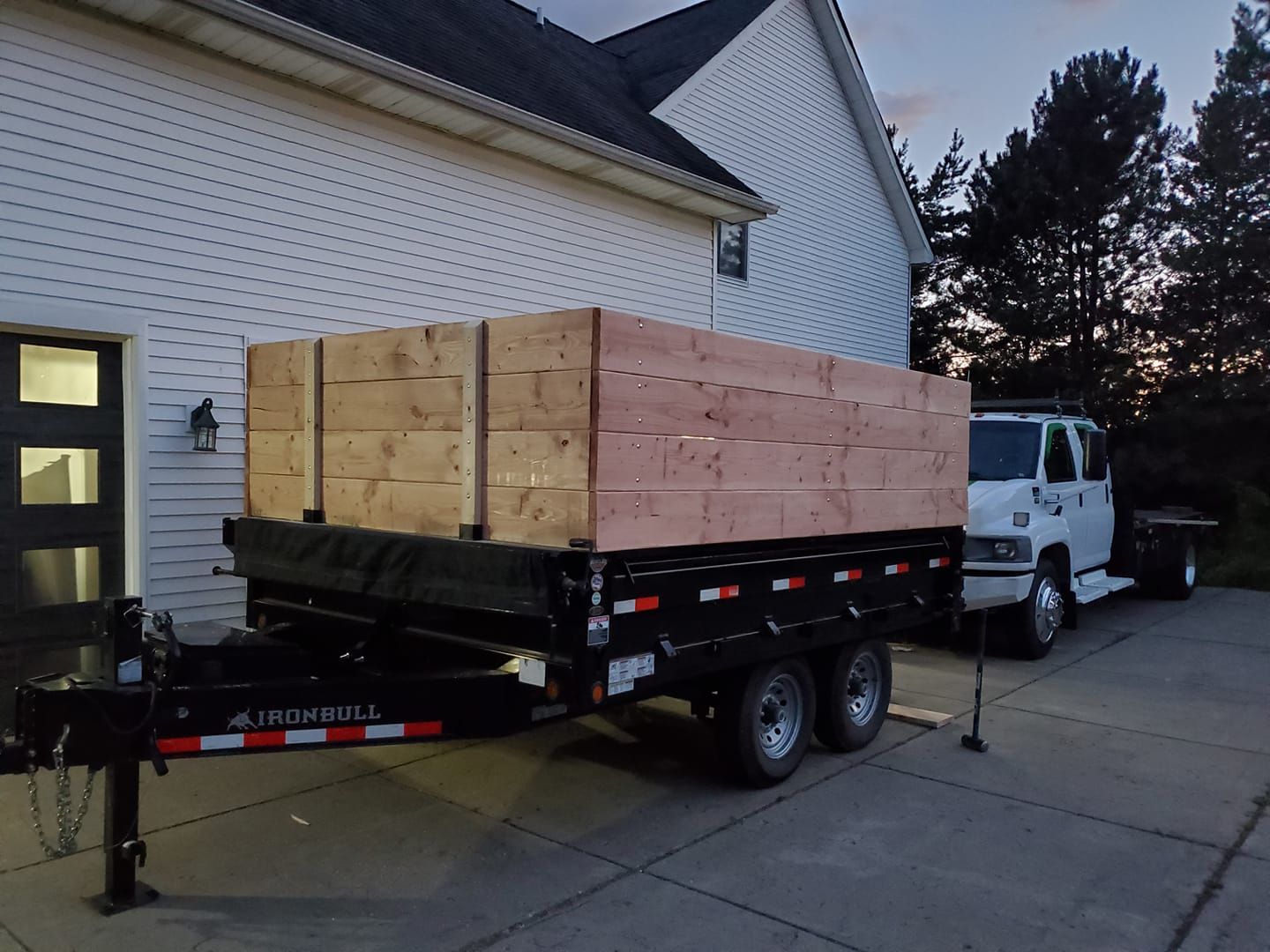 A dump truck is pulling a trailer with wooden boxes on it.