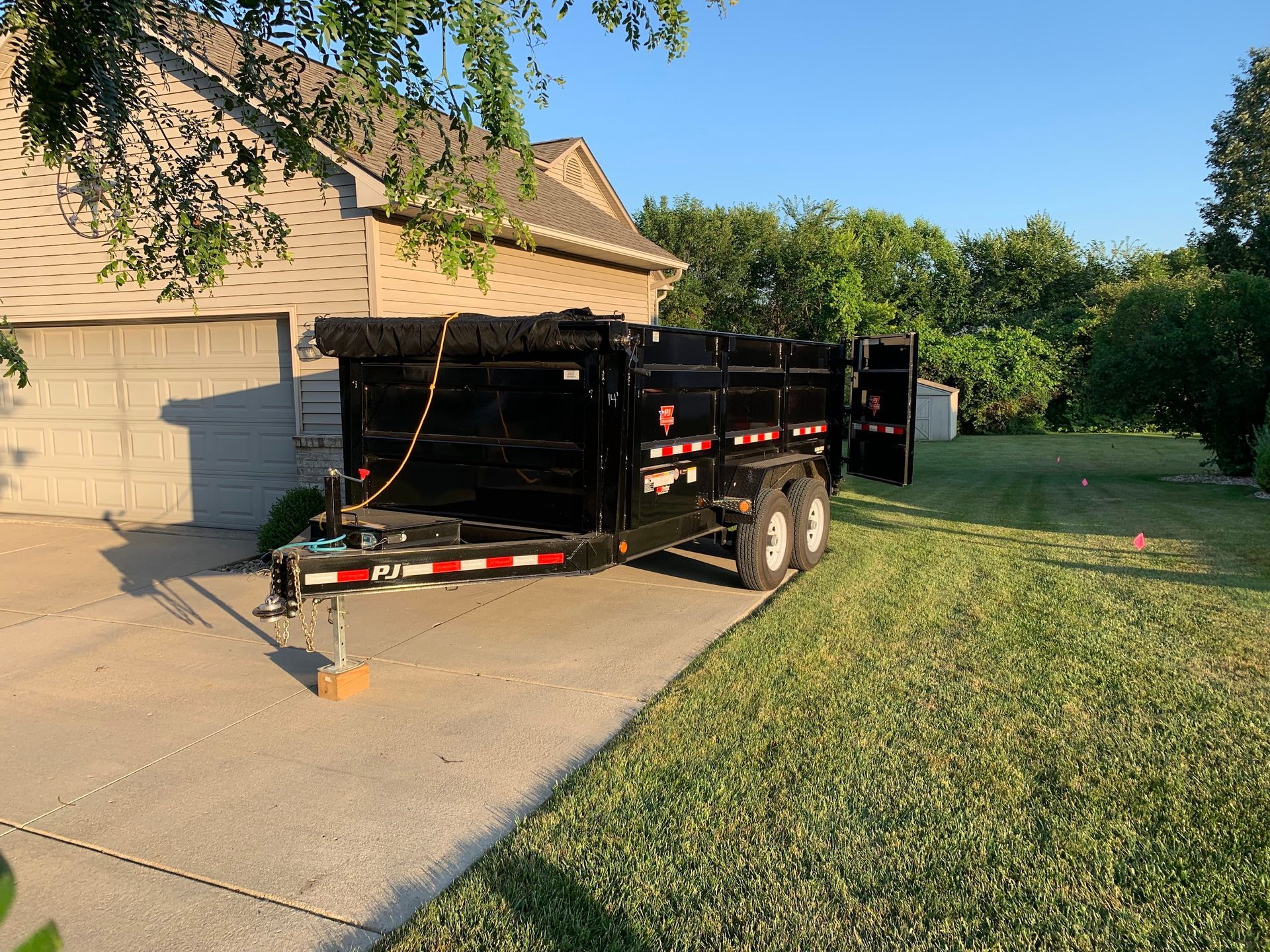 A dumpster trailer is parked in front of a house.