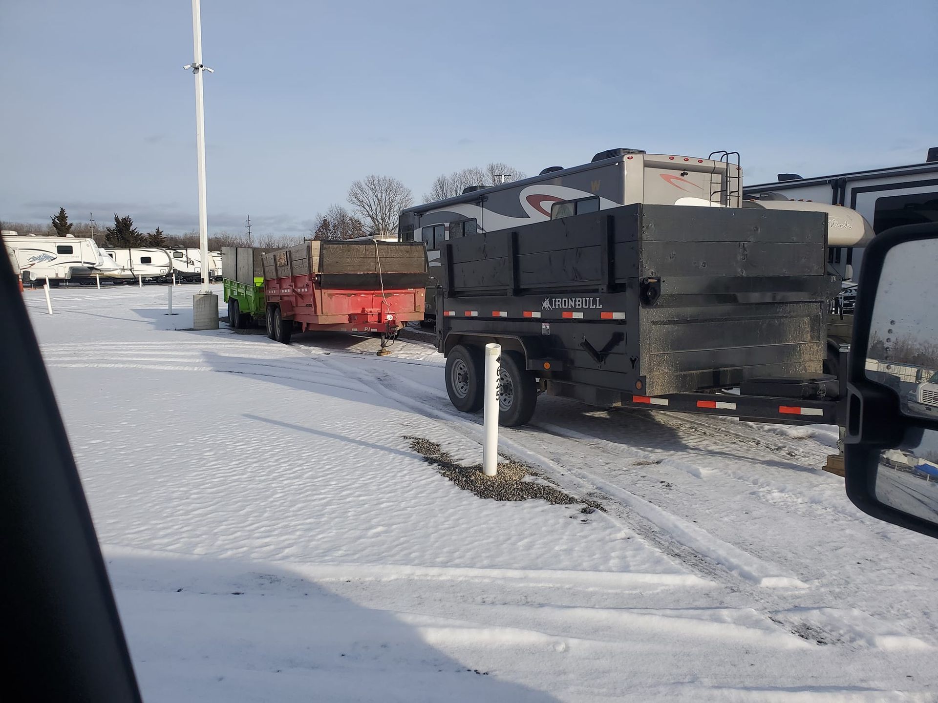 A truck and trailer are parked in a snowy parking lot