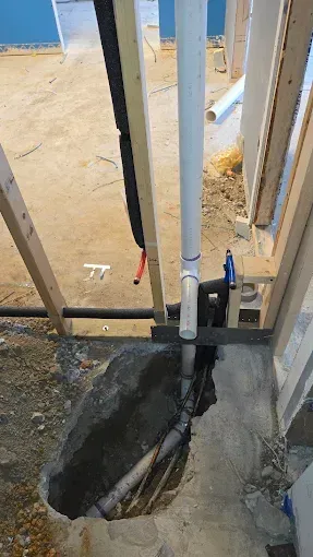 Brass irrigation backflow preventer with green-handled valves and copper pipes in an outdoor setting.