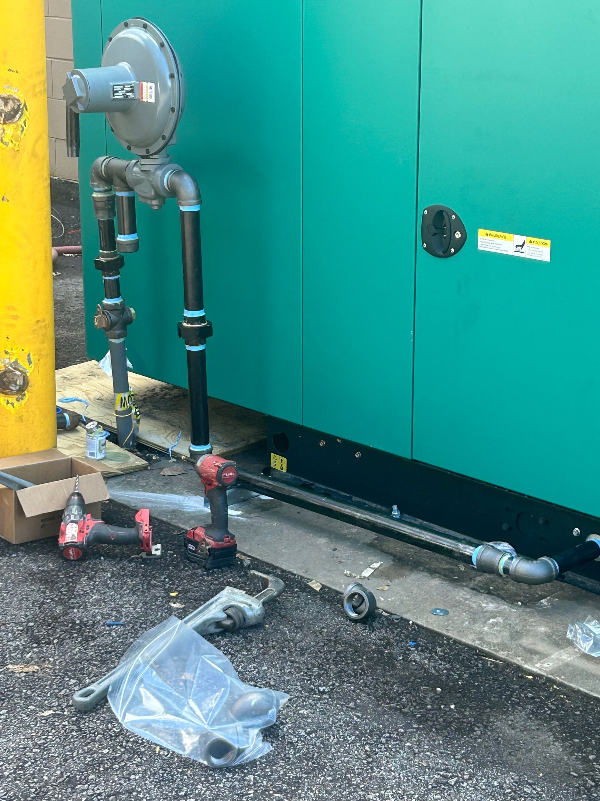 Plumber holding red pipe wrench, standing near a toolbox and sink.